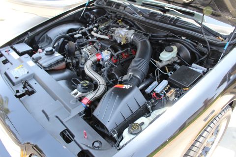 2003 Ford Crown Victoria - engine bay view with a black K&N intake, brake fluid reservoir, alternator and red anodized fittings.