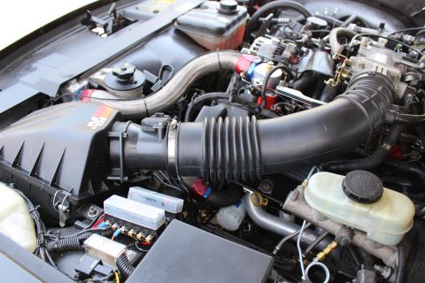 2003 Ford Crown Victoria - Engine bay showing a black K&N air box and corrugated intake tube routed to the throttle body beside the brake master cylinder.