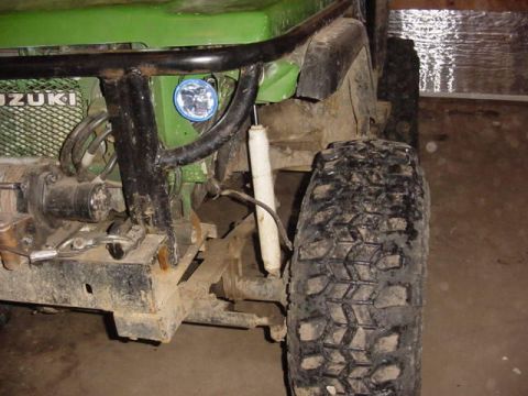 1992 Ford Bronco - Front view of a green off-road vehicle, a winch and aggressive tire tread.