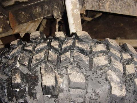 1992 Ford Bronco - Mud-caked tire tread shows aggressive off-road design.