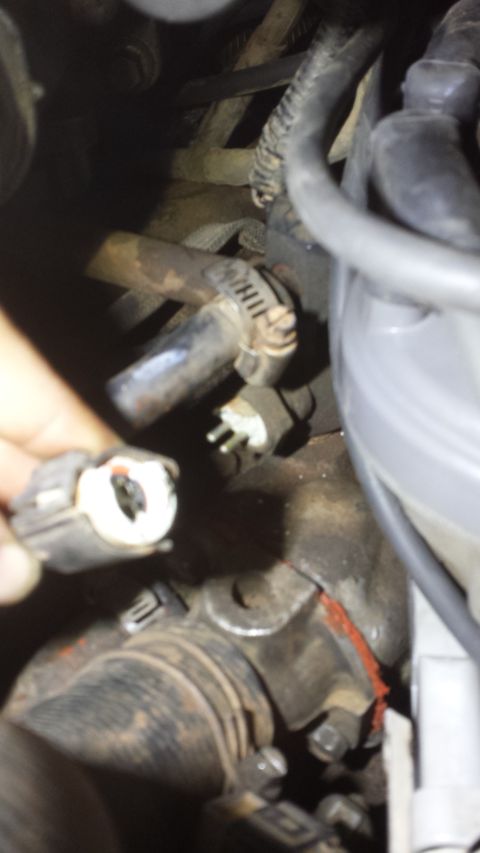 1990 Ford Bronco - Close-up view of engine components and a disconnected electrical connector.