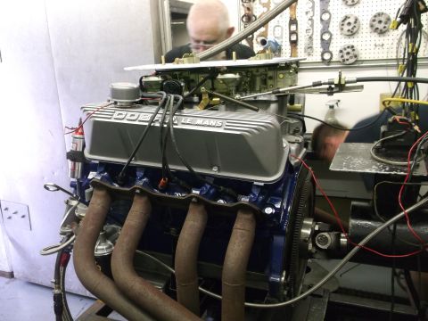1967 Ford Mustang - A V8 engine with Cobra Le Mans valve covers is being worked on in a garage setting.
