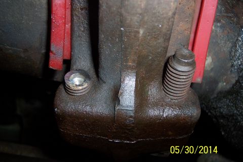 1978 Ford Bronco - This photo shows a close-up of a bolt on a vehicle's exhaust manifold, with red support brackets in the background.