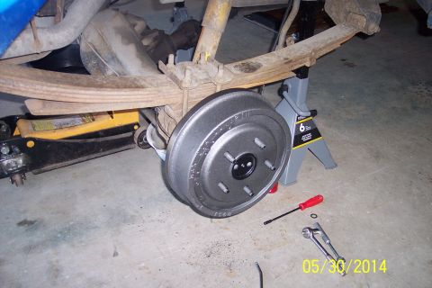 1978 Ford Bronco - Rear drum brake assembly being worked on, supported by jack stands.