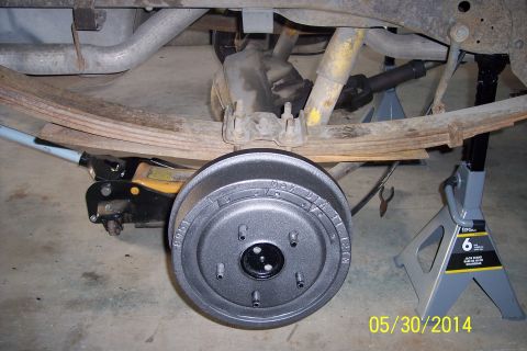1978 Ford Bronco - The rear drum brake assembly is shown with a jack and jack stands supporting the vehicle.