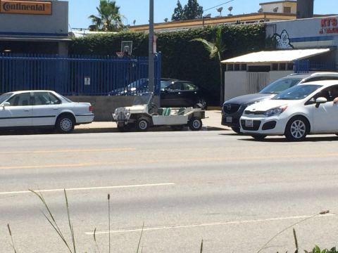 1968 Ford Mustang - A white Moke-style buggy is parked on the side of a street with other vehicles nearby.