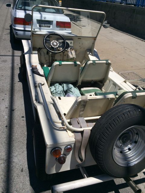 1968 Ford Mustang - A cream-colored off-road vehicle is parked behind a white car on a street.