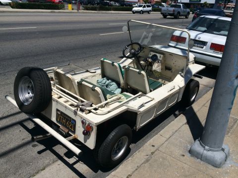 1968 Ford Mustang - This off-road utility vehicle, possibly a Moke, is parked on a sunny street with a spare tire mounted on the back.