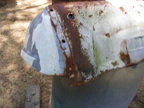 rusted metal panel with peeling paint, possibly from a vehicle