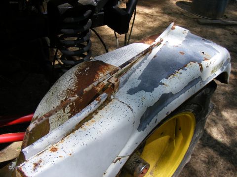 Rusted white fender and yellow wheel