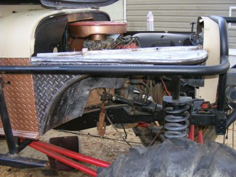 Off-road vehicle engine bay with copper air cleaner housing and diamond plate fender liner