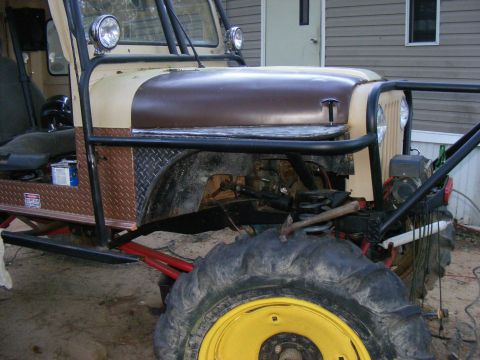 Modified off-road vehicle with large tires, roll cage, and diamond plate accents. Hood is brown and tan