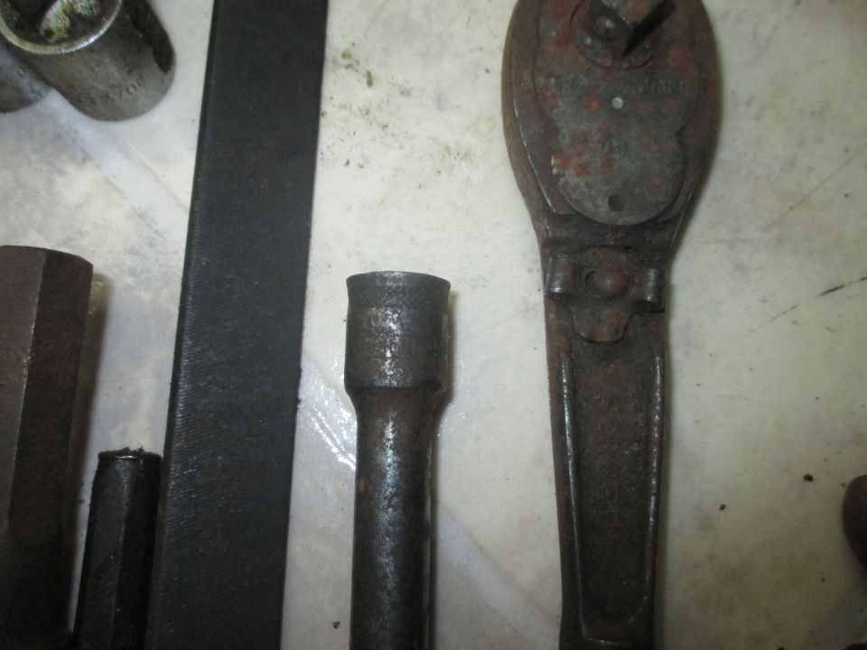 Close-up of a rusty ratchet and socket set on a surface