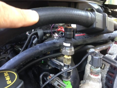 2002 Ford Mustang - Close-up view of an engine sensor, with the SAE 5W-20 oil cap also visible in the frame.