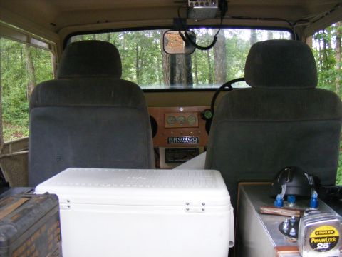 Interior view of a 1978 Ford Bronco with a cooler and dashboard gauges