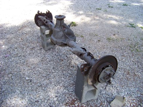 1999 Mercury Grand Marquis - This is a rear axle assembly with brake rotors, resting on concrete blocks outdoors.