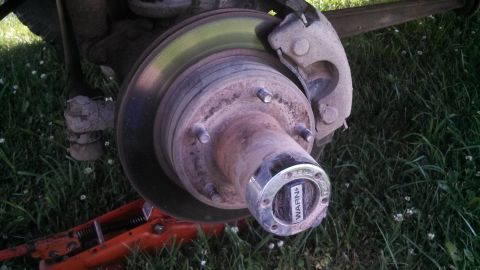 1979 Ford Bronco - A close-up view of a vehicle's front wheel hub assembly, a WARN locking mechanism.