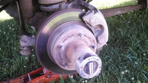 1979 Ford Bronco - Vehicle brake rotor, caliper, and hub assembly with a WARN locking hub is visible.