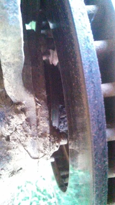 1979 Ford Bronco - Detail of a vehicle's wheel hub and suspension components, showing rust and dirt.