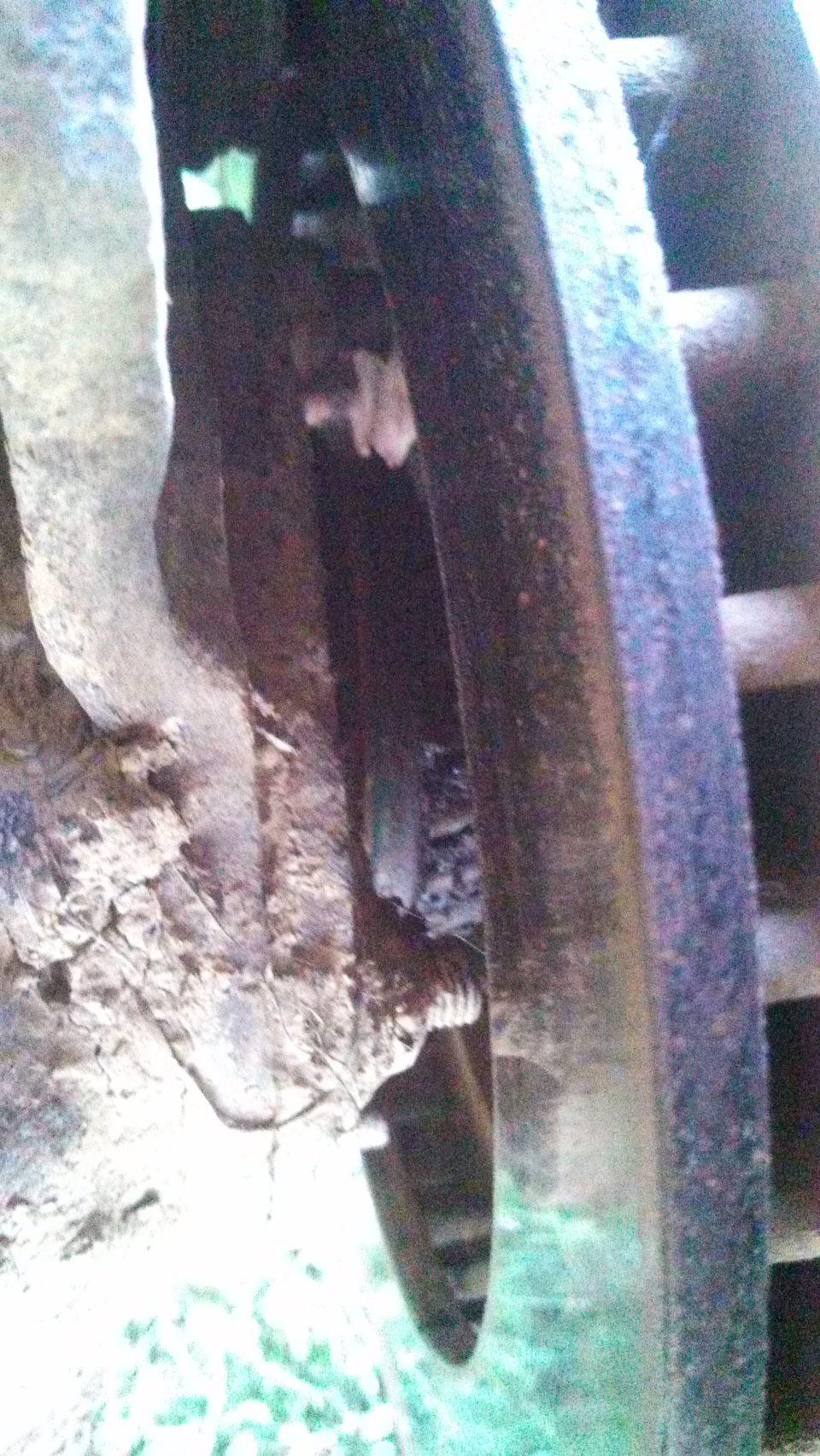 Close-up of a rusty wheel hub and suspension parts, with a Supermotors.net logo at the bottom