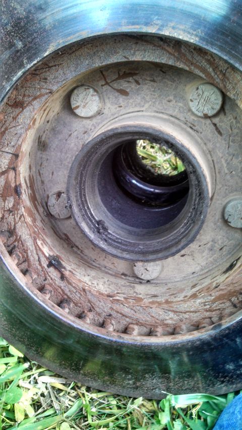 1979 Ford Bronco - A close-up view of a vehicle's wheel hub and brake rotor, showing signs of wear and tear.