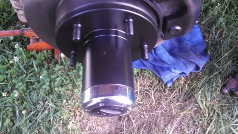 1979 Ford Bronco - Close-up of a vehicle's wheel hub assembly, a black painted hub and a shiny chrome trim ring.