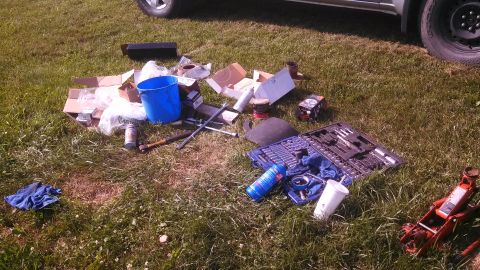 1979 Ford Bronco - Tools and parts are scattered on the lawn, with a vehicle partially visible in the background.