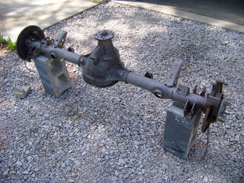 1999 Mercury Grand Marquis - A rear axle assembly is shown, supported by cinder blocks on a gravel surface.