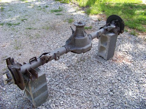 1999 Mercury Grand Marquis - Rear axle assembly, likely from a sedan, is supported by concrete blocks outdoors.