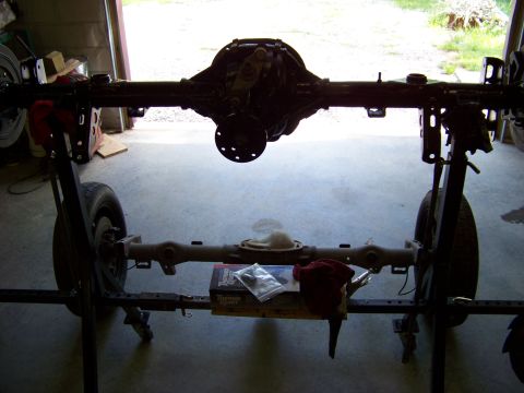 1999 Mercury Grand Marquis - A car's rear axle assembly is displayed on a stand in a garage setting.