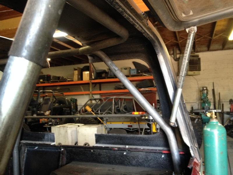 Roll cage inside a vehicle, with shelves and other vehicles in the background