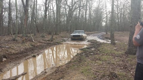 1979 Ford Bronco - 1979 Ford Bronco navigates a muddy obstacle on a forest trail.