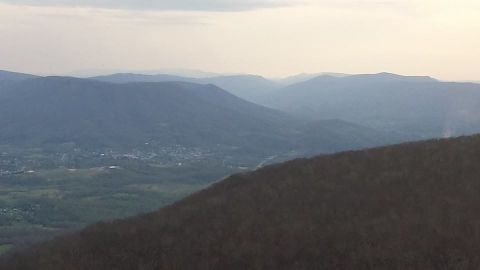 1979 Ford Bronco - A hazy view of rolling mountains and a valley town, with the Supermotors logo visible in the corner.