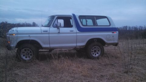 1979 Ford Bronco - This 1979 Ford Bronco, seen in a field, features a two-tone white and blue paint scheme.