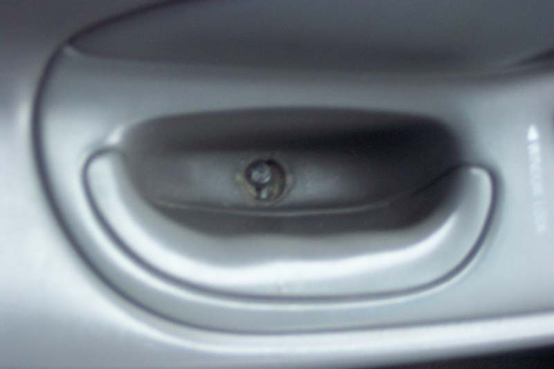 Close-up of a car's interior door handle with a visible screw