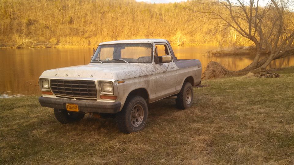 1979 Ford Bronco parked by a river, 3q-front view, dirty exterior