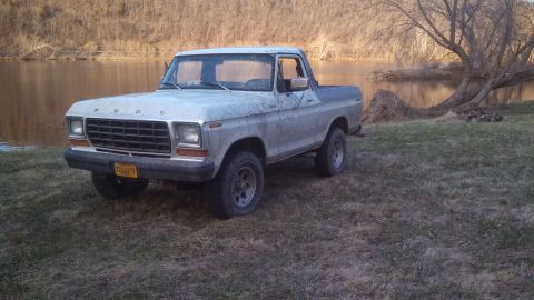 1979 Ford Bronco - This Ford Bronco is parked on a grassy area next to a calm body of water.
