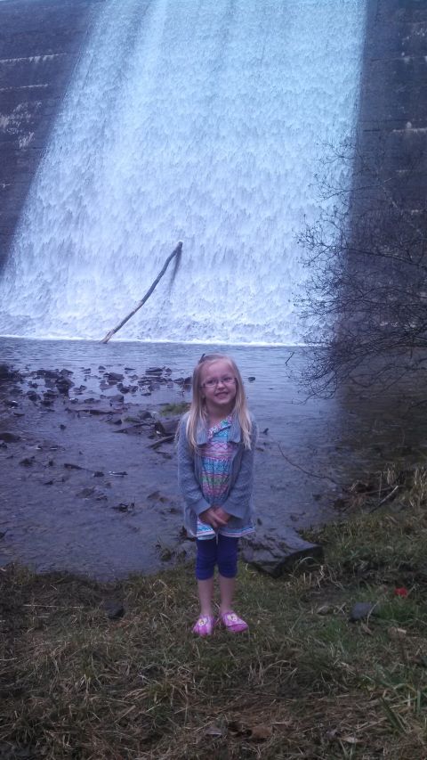 1979 Ford Bronco - A young girl smiles while standing on the shore in front of a cascading waterfall.