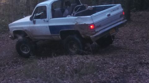 1979 Ford Bronco - Pickup truck with lifted suspension navigating rough terrain off-road.