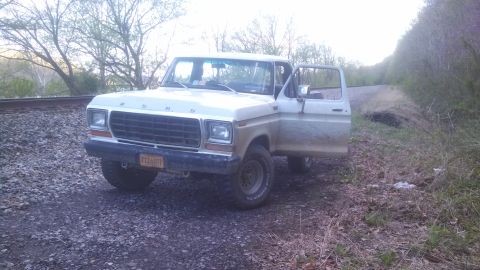 1979 Ford Bronco - This 1979 Ford Bronco is parked on a gravel road beside railroad tracks, with its driver's door ajar.