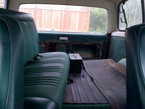1978 Ford Bronco - Rear interior view of a 1978 Ford Bronco, green vinyl seats and a wooden floor.