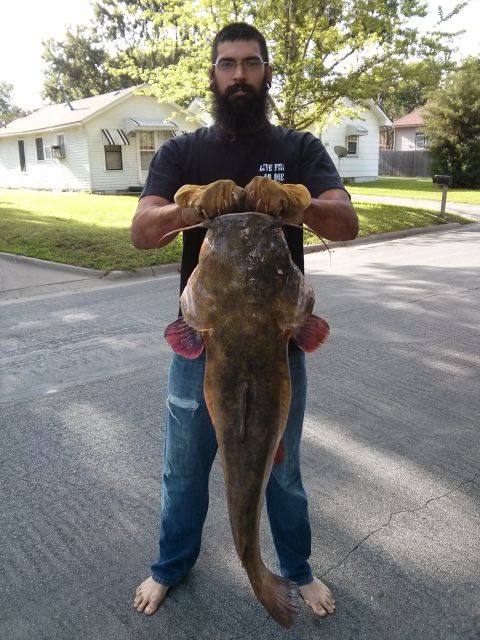 1986 Ford Bronco - A man proudly displays a large catfish he has caught.