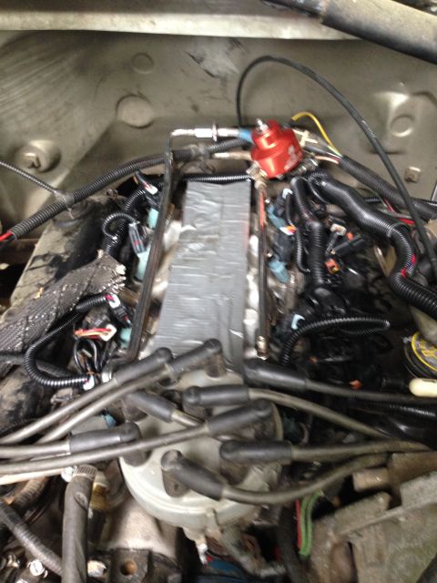 1988 Ford Bronco - Close-up view of an engine bay, showing a red fuel pressure regulator and numerous spark plug wires.
