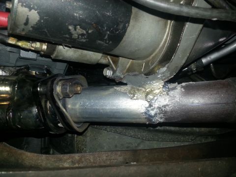 1994 Ford Bronco - Exhaust pipe repair showing welding work near the starter motor.
