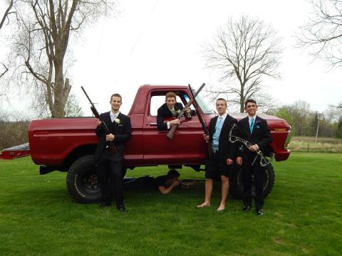 1978 Ford Bronco - A group of young men pose with firearms and a bow next to a red pickup truck.