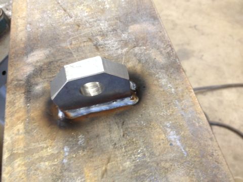 1978 Ford Bronco - A close-up view of a custom-welded metal component, likely a bracket or adapter, a hexagonal nut with a central threaded hole.