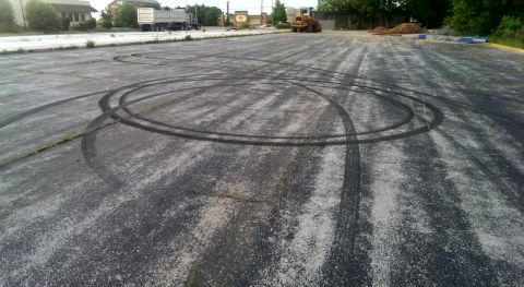 2000 Mercury Grand Marquis - Tire marks on asphalt in a parking lot, with a Supermotors.net logo in the corner.