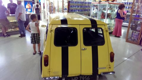 2000 Mercury Grand Marquis - Yellow van with black stripes is seen from the rear in an indoor setting.