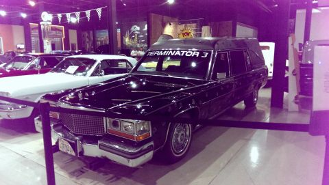 2000 Mercury Grand Marquis - This hearse, labeled "TERMINATOR 3", is on display indoors alongside other vehicles.