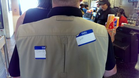 2000 Mercury Grand Marquis - Two people wearing name tags are seen from behind in what appears to be a public establishment.